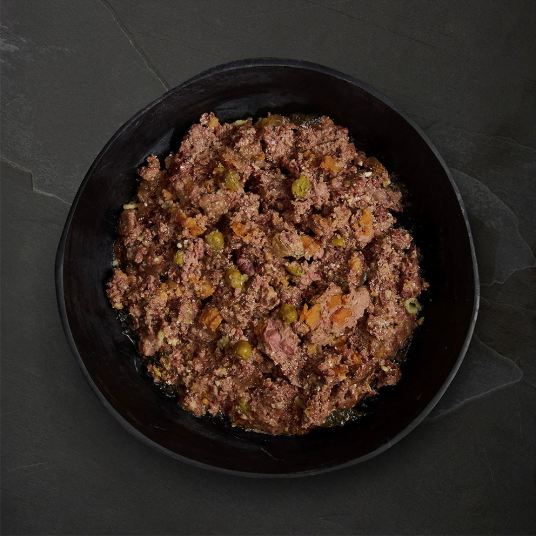 Canagan Puppy Feast Wet Food 400g served in a bowl. Chunky mince like texture with vegetables.