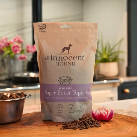 Bag of The Innocent Hound Super Boost Topper on wooden counter with a small pile of the topper in the foreground.