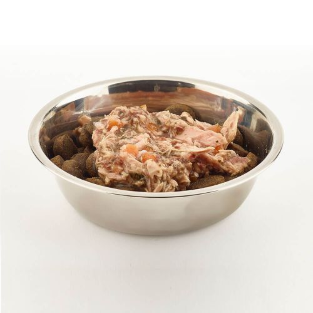 Fish 4 Dogs Finest Tuna with Spinach and Carrot open in a bowl, on top of kibble, against a white background.