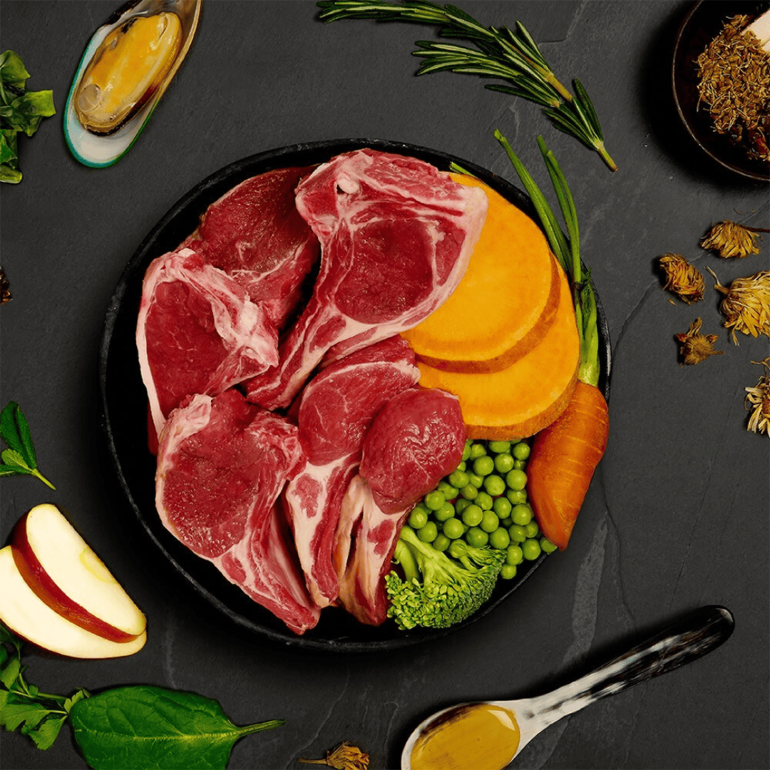 Fresh Ingredients of nthe Canagan Shepherd's Pie Wet Dog Food 400g. shown in a bowl. There are some functional additives like the green lipped mussel scattered around the bowl on the counter space.