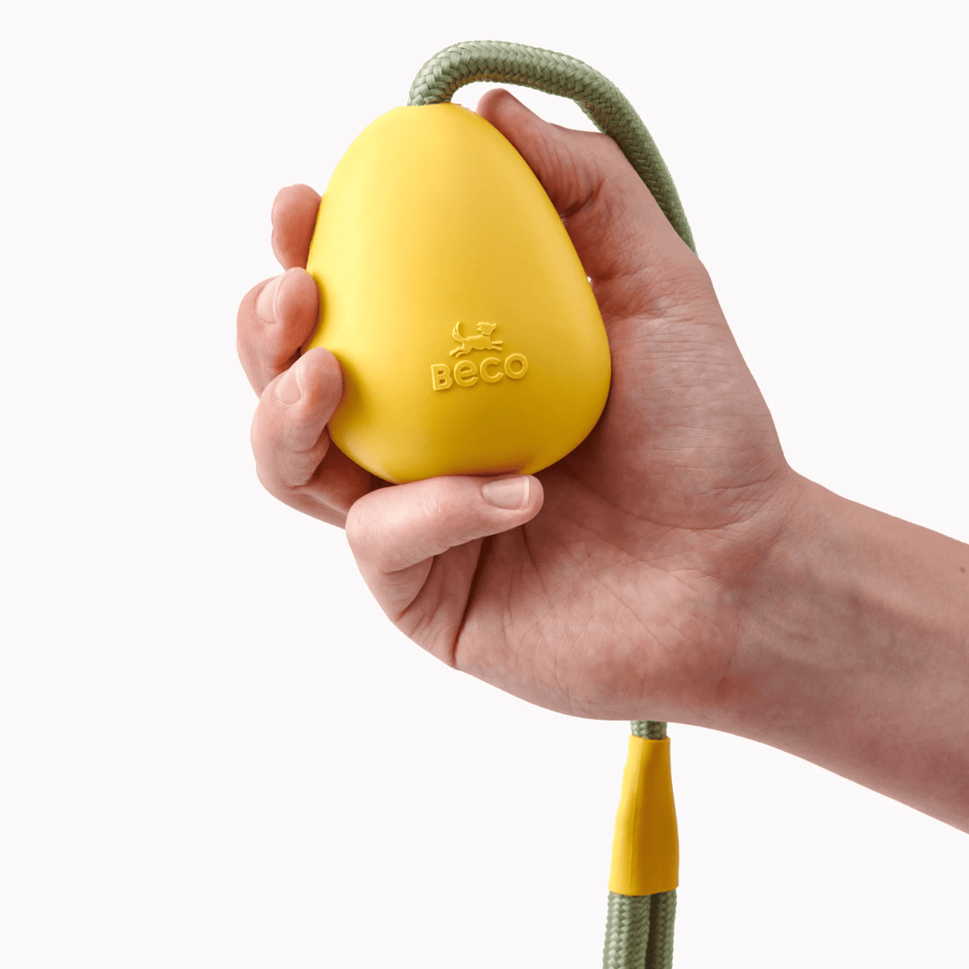 Beco Yellow Rubber Slinger Pebble in a persons hand