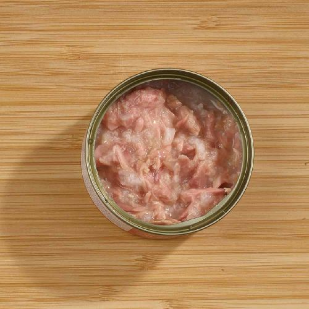 The Fish 4 Cats Tuna & Salmon cat food tin. The lid is off and we can see the soft consistency inside. Shot with an ariel view.