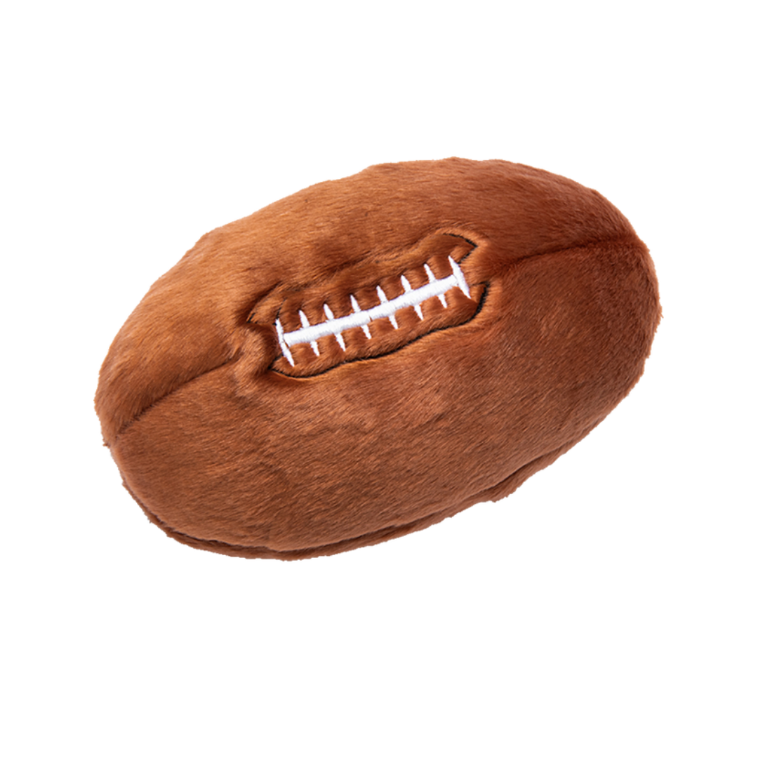 Fluff & Tuff Football Plush Dog Toy against a white background. It is brown in colour and white stitching to mimic that of a football.
