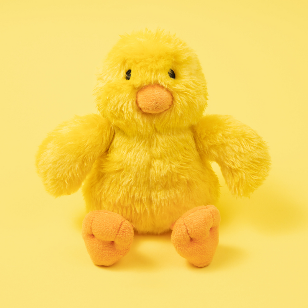 Fluff & Tuff Howie Duck Plush Dog Toy against a yellow background. Toy is a yellow colour with an orange beak and feet.