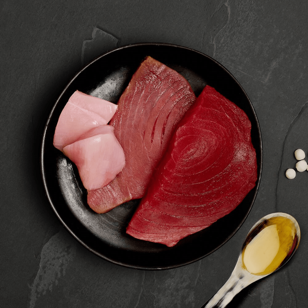 The fresh ingredients of the Canagan Tuna with Chicken Cat Tin 75g displayed on a plate.