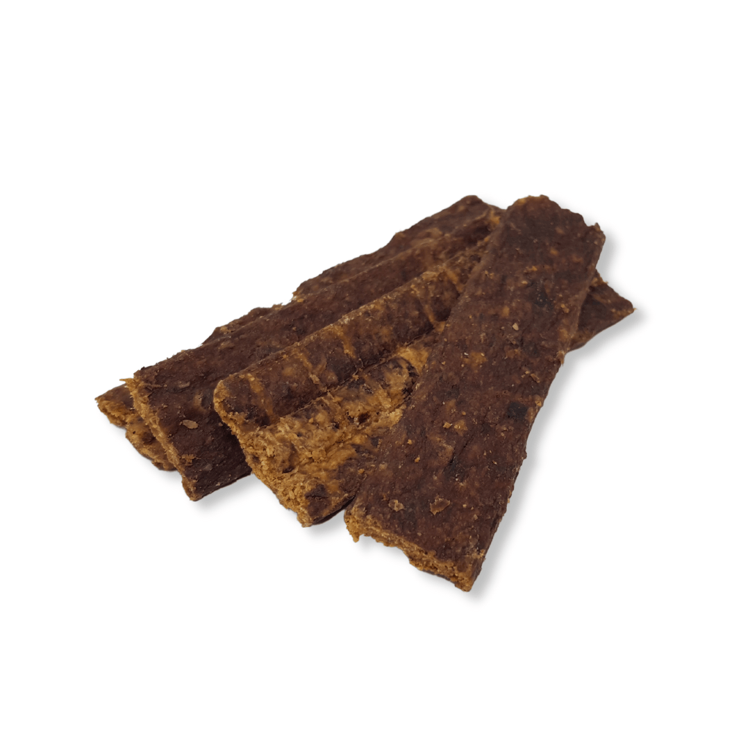 Three lamb strips dog treats stacked on a white background