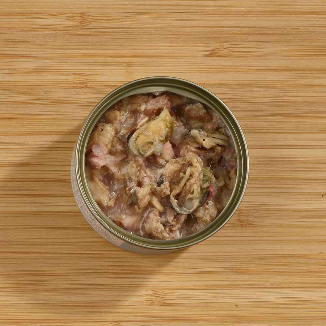 The Fish 4 Cats Sardine and Mussel cat food tin. The lid is off and we can see the soft consistency and chunks of mussel inside. Shot with an ariel view.