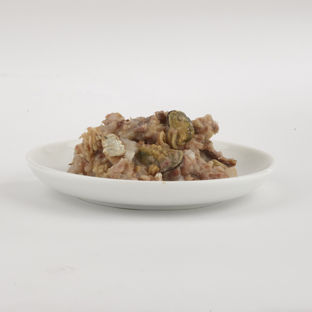 The Fish 4 Cats Sardine & cat food served on a plate with a soft, fish consistency, there are chunks of mussels too.