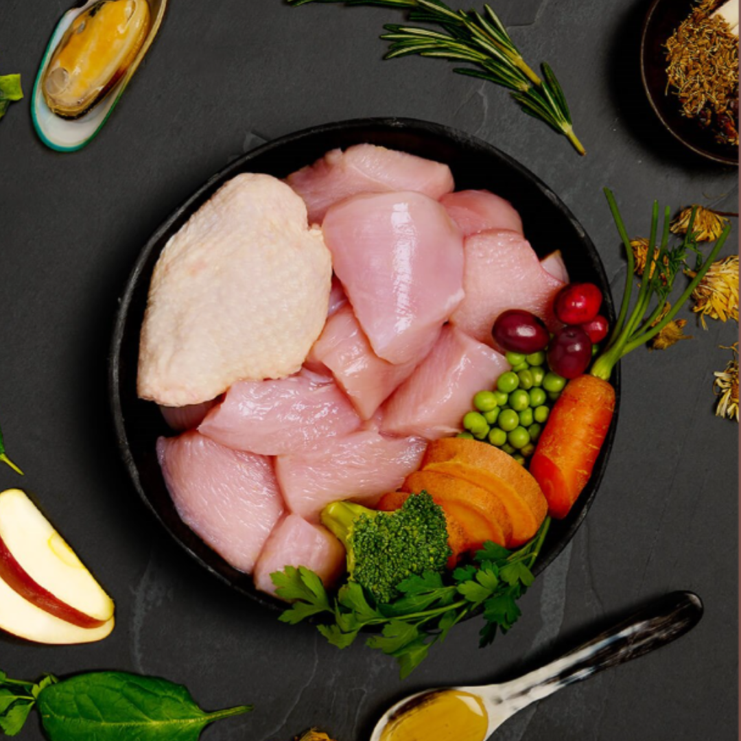 The fresh ingredients of the Canagan Senior Feast Wet Dog Food 400g in a bowl. There are other functional additions placed around the bowl including green lipped mussels.