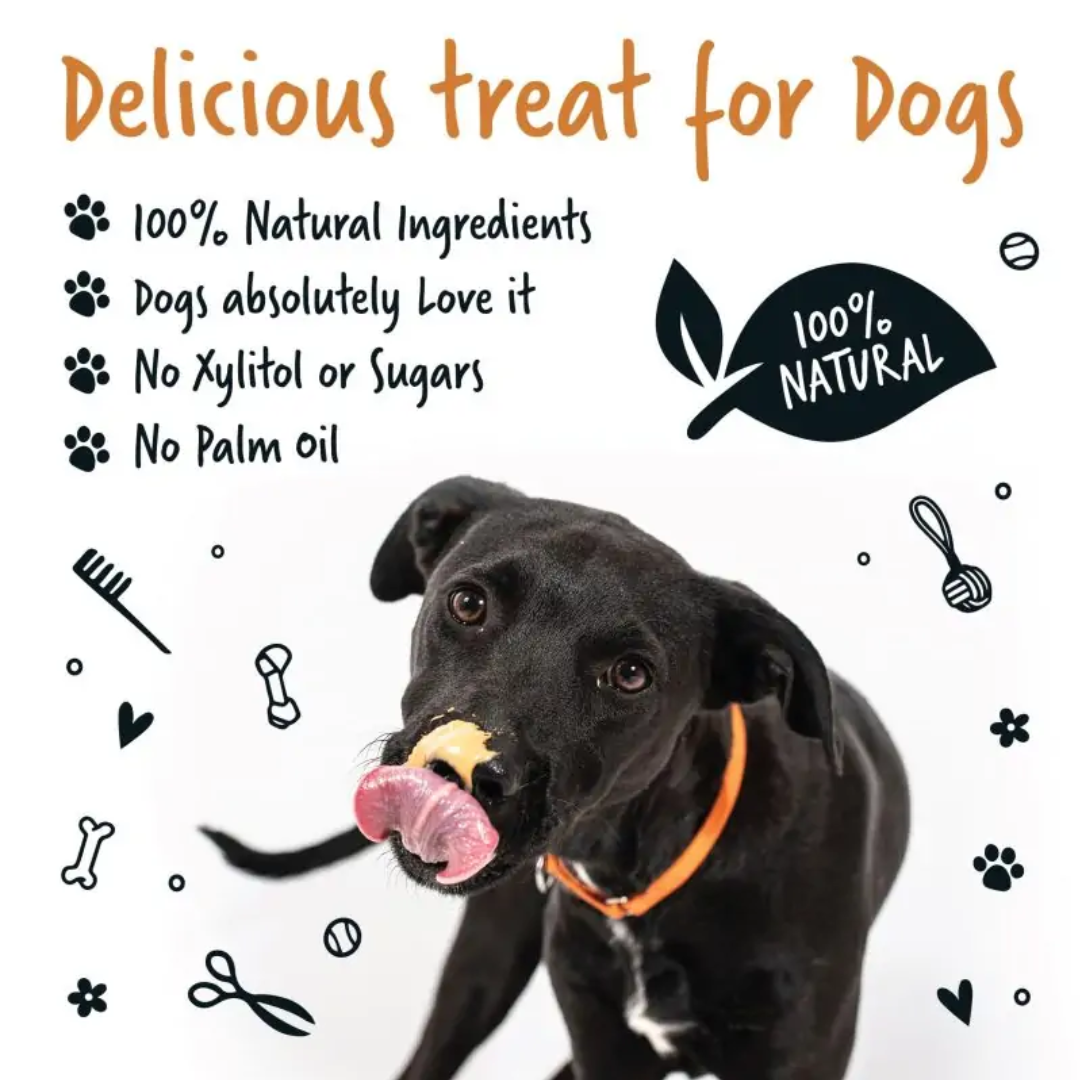 Black dog licking peanut butter from their nose, to the right of text saying "Delicious Treat for Dogs. 100% Natural Ingredients. Dogs absolutely love it. No xylitol or sugars. No palm oil."