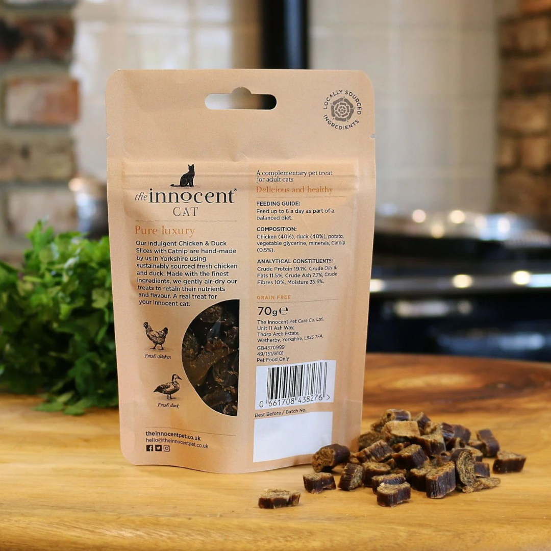 The back of an Innocent Cat Chicken and Duck Slices with some loose on the table.