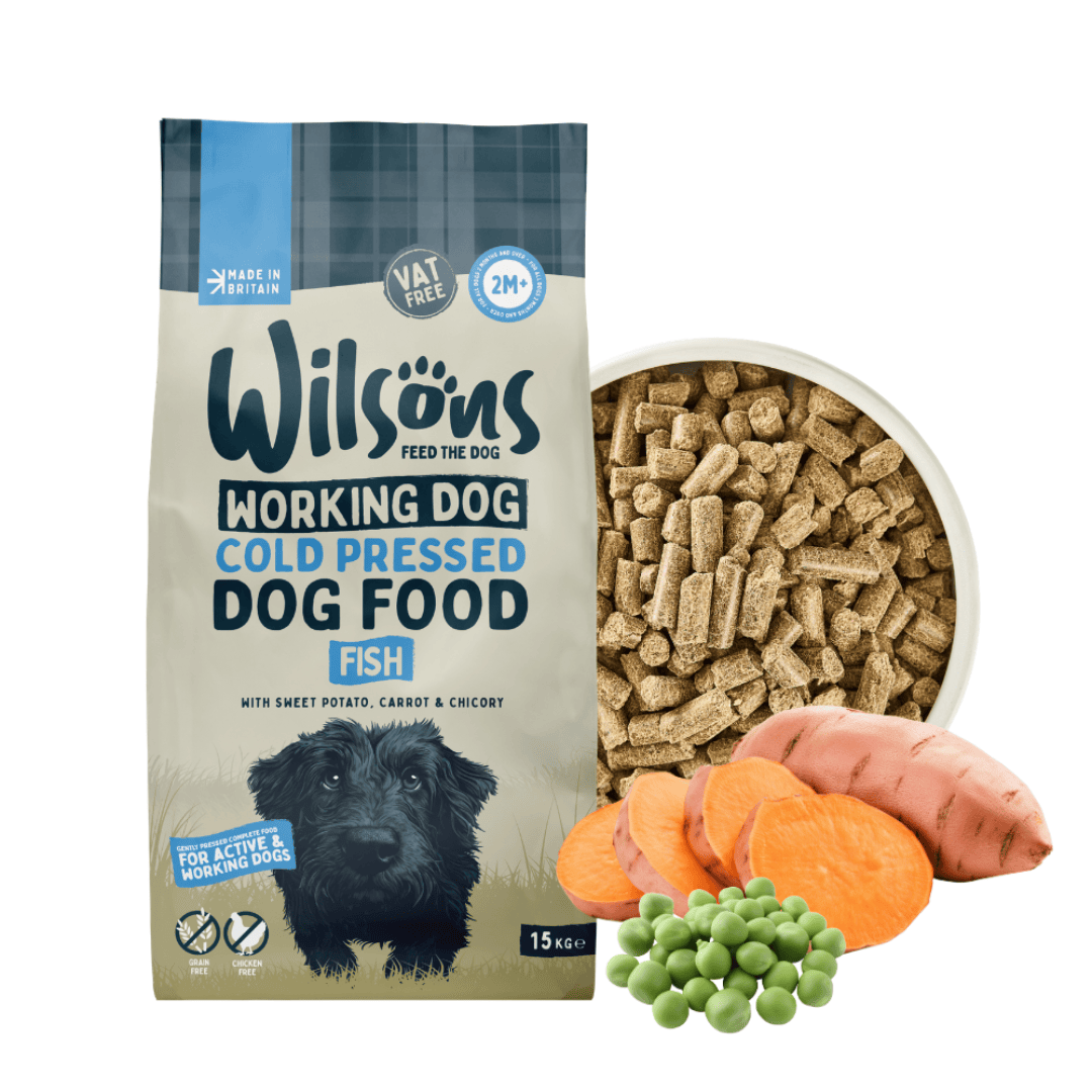 A bag of Wilsons Working Dog Cold Pressed Dog Food, Fish, shown next to a bowl filled with kibble, with sweet potato, peas, and carrots illustrated at the bottom to represent ingredients.
