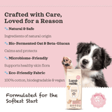 Dog with Luminoble wipes packaging on a pink background with text about product features.