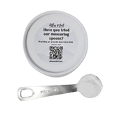 silver measuring spoon with measurements etched on, and a container with a sticker laying on a white background