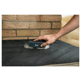 A human hand is using the proper pets hair removing brush to remove loose fur from a dog bed.