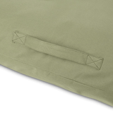 Close-up of a green fabric with a handle detail sewed in on a white background