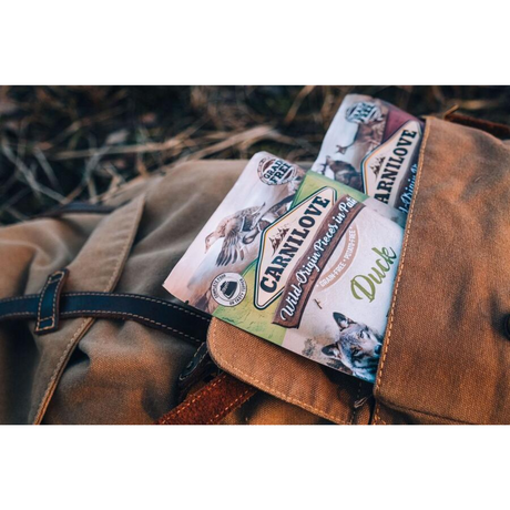 The Carnilove Dck with Timothy Grass pouch sticking out of a rugsack. 